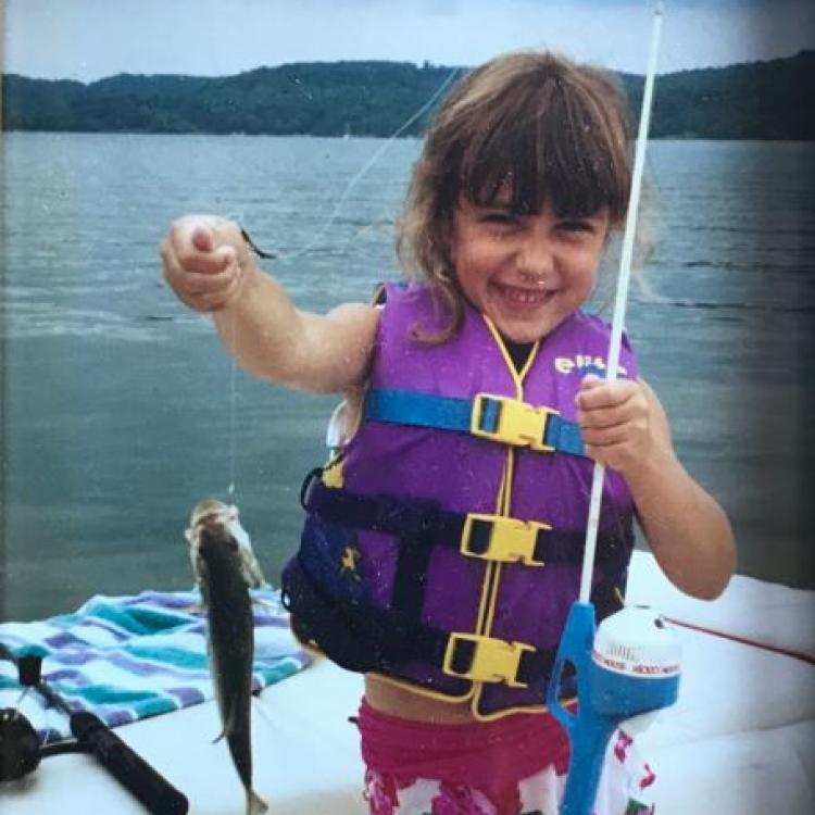 girl smiling holding a fish