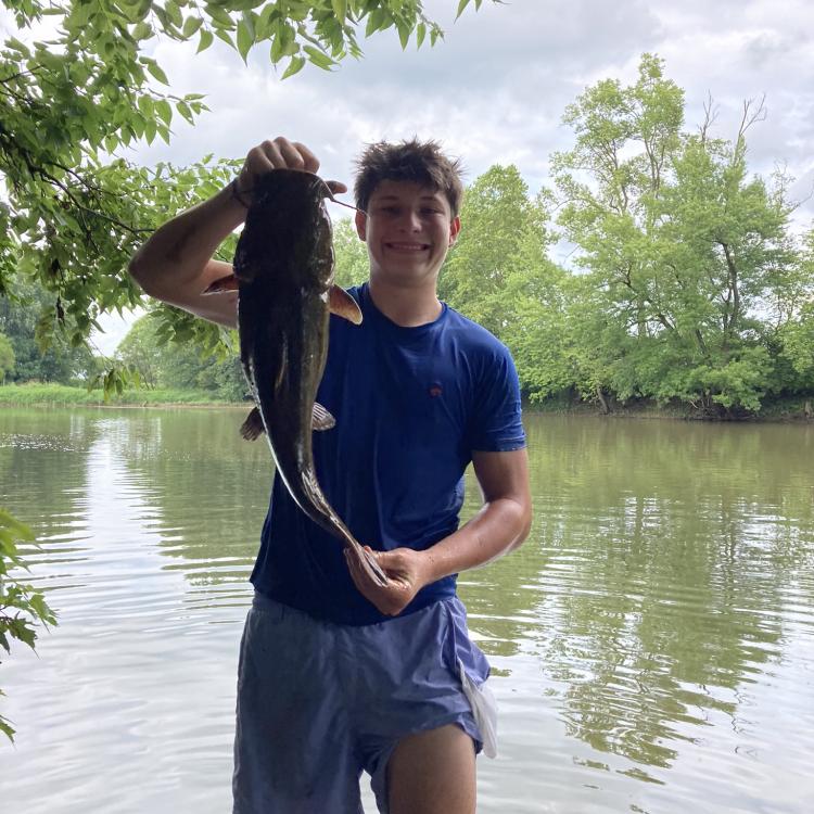 boy smiling holding a fish
