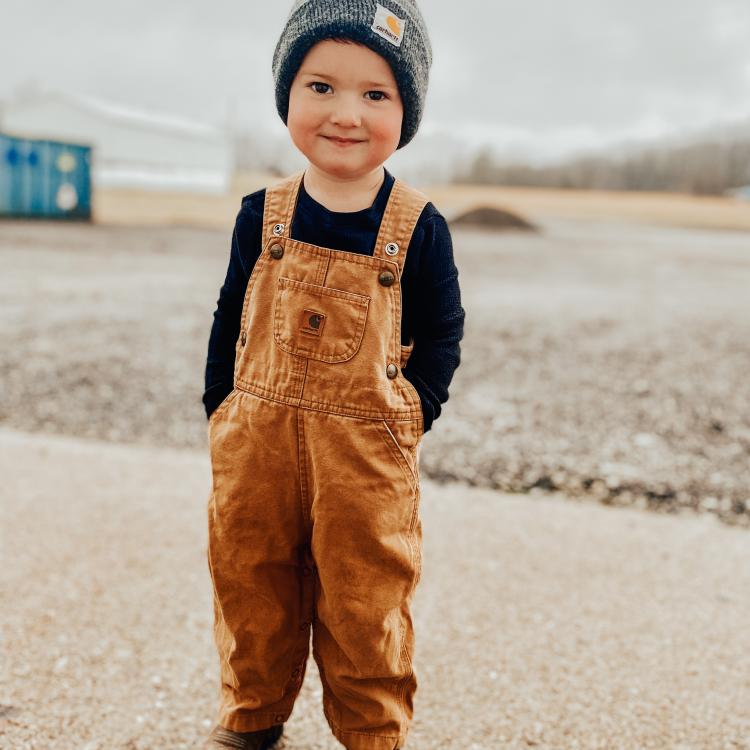 boy in overalls outside in winter