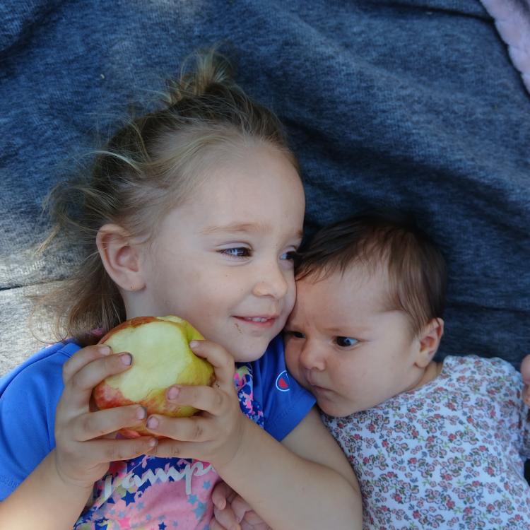 little girl and baby lying together