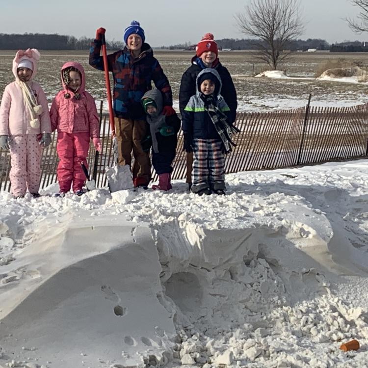 Children stand on top of snow drifts