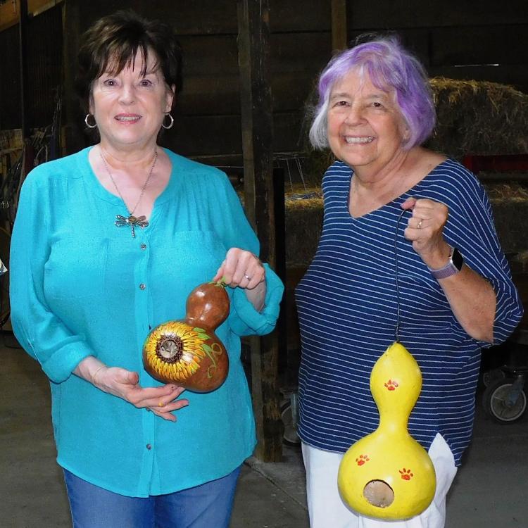 two women holding painted gourds