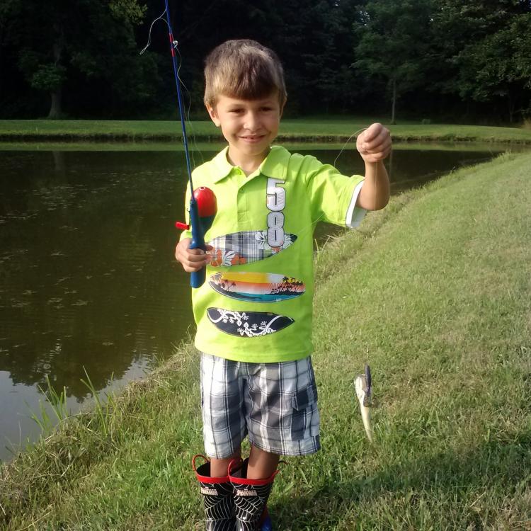 boy smiling holding a fish