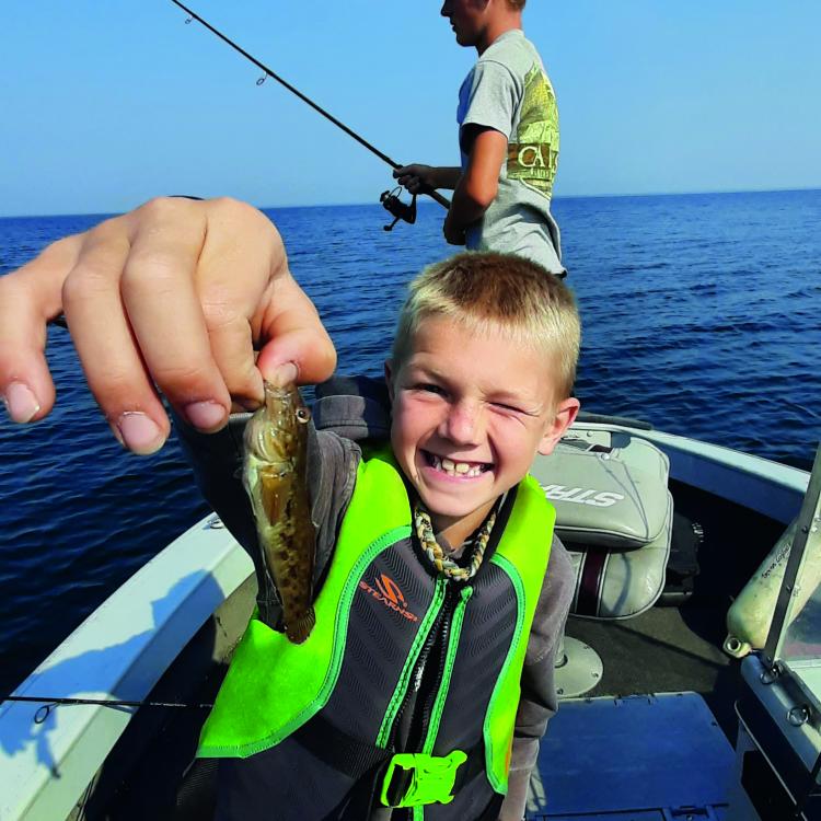 boy smiling holding a minnow 