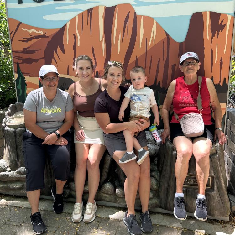 family sitting in front of Toledo Zoo sign