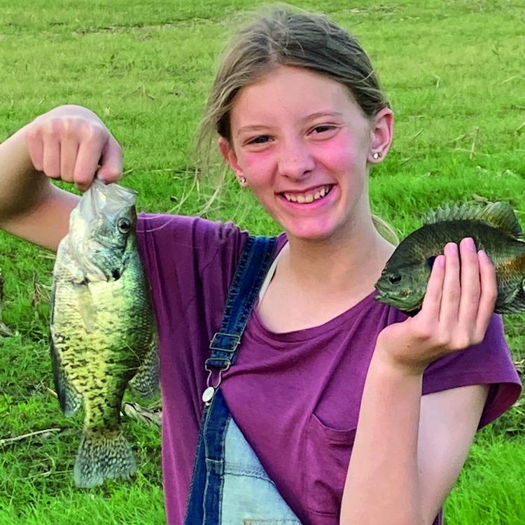 girl smiling holding two fish