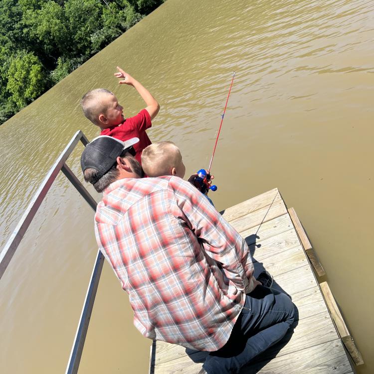 two little boys fishing with their dad