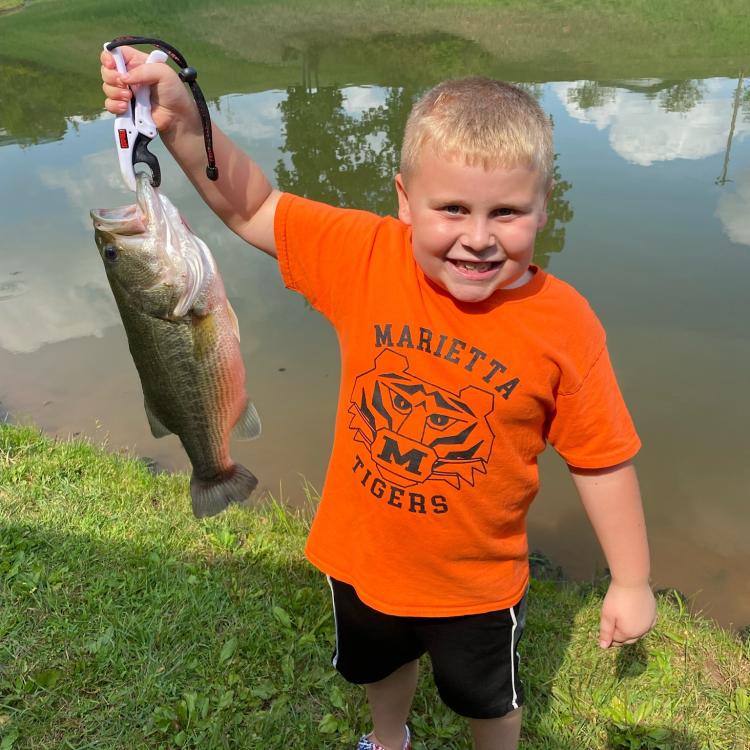 Boy smiling holding fish