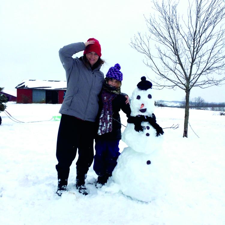 woman and girl next to a snowman