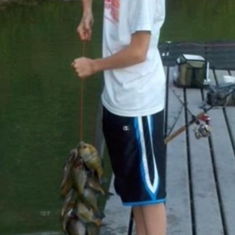 boy smiling while holding a line fish
