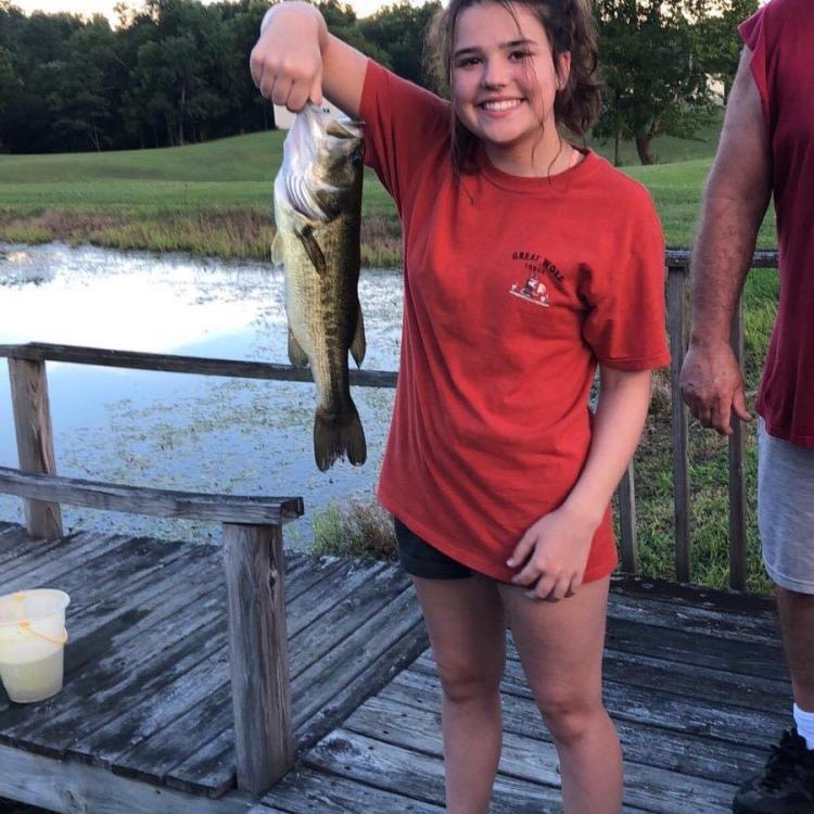 girl smiling holding fish