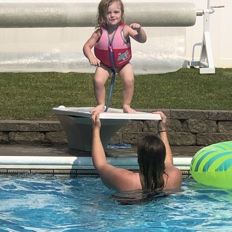 little girl in life jacket on diving board