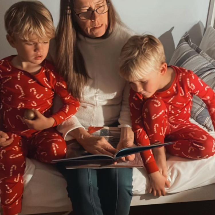 woman reading to two small boys