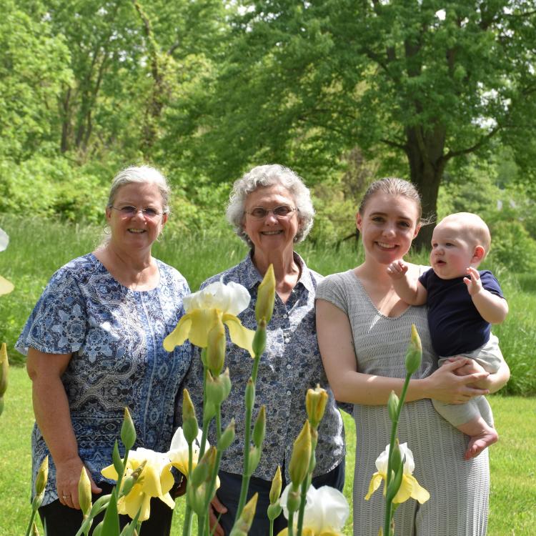 three women and a baby in a garden