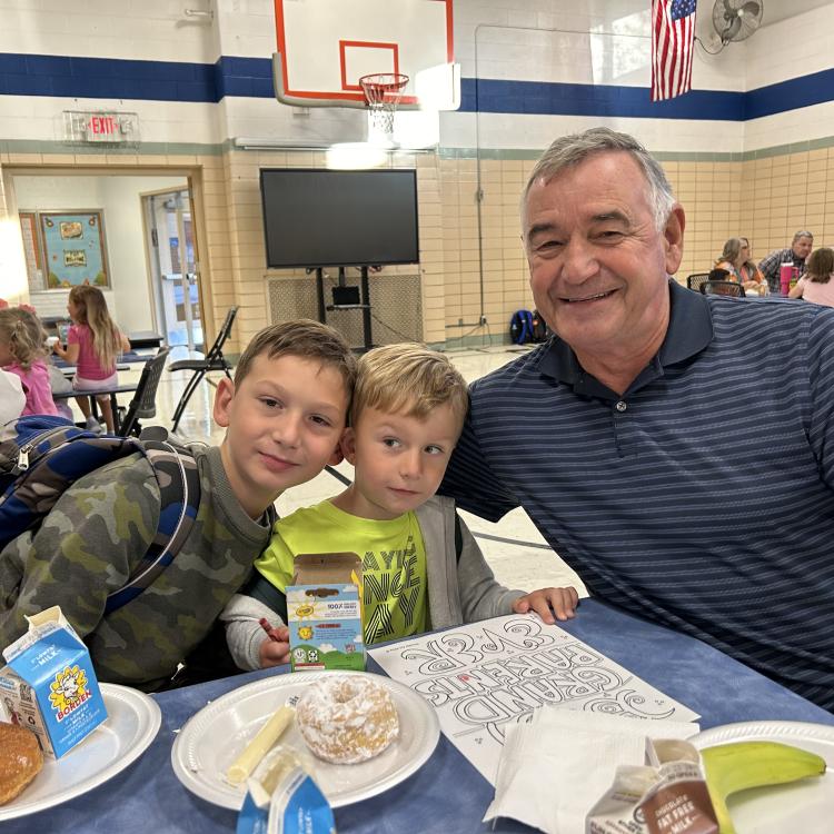 man at lunch table with two small boys