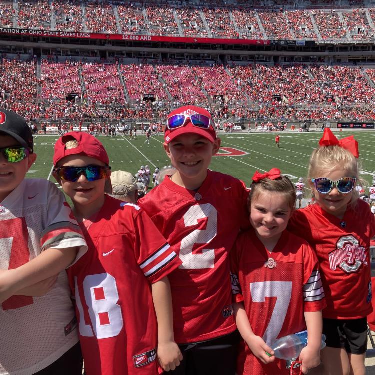 five kids in Ohio state gear in front of football field