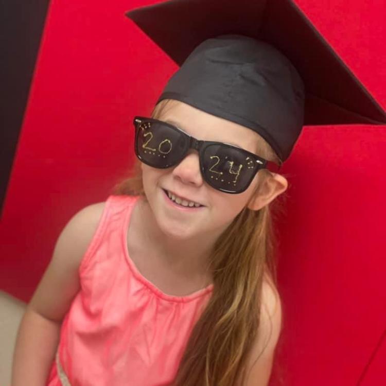 little girl in black graduation cap and sunglasses