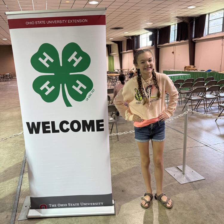 girl by 4-H sign