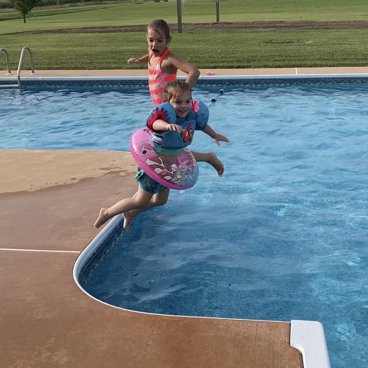 two small children jump into pool