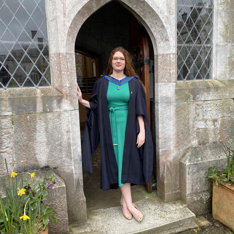 young woman in black graduation gown