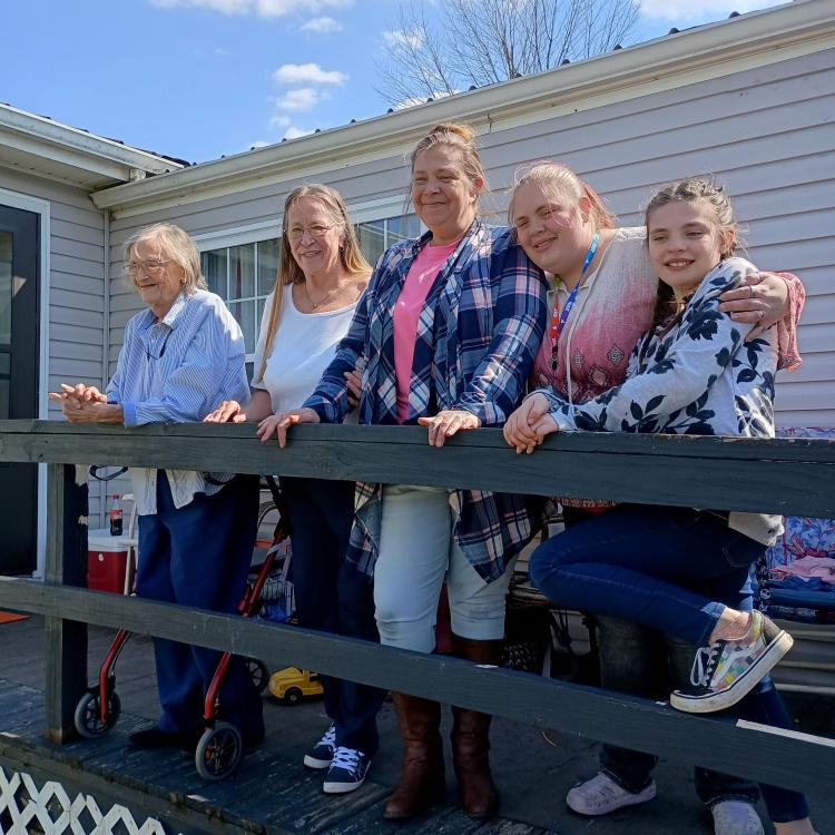 four women and a girl, standing on a deck