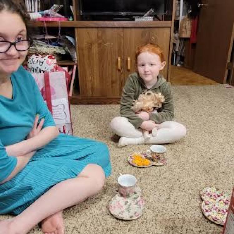 two people having tea party on the floor