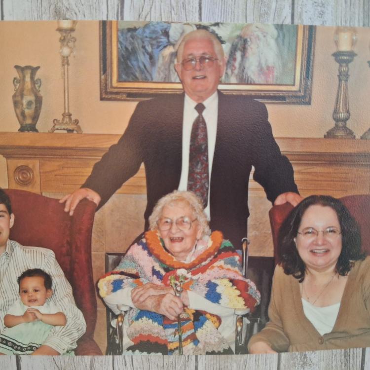 several generations pose in front of fireplace