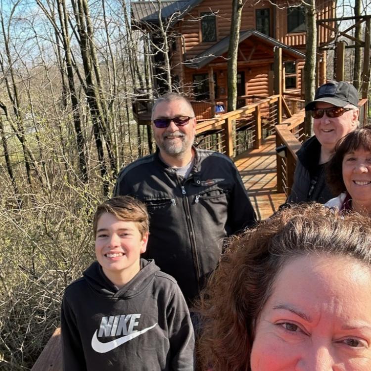 family in front of cabin in the woods