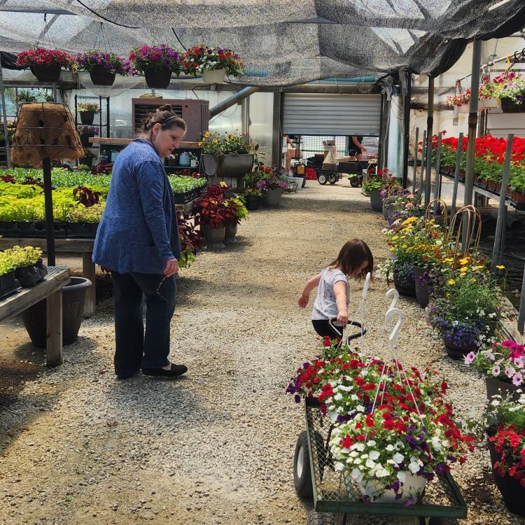 woman and small girl in greenhouse