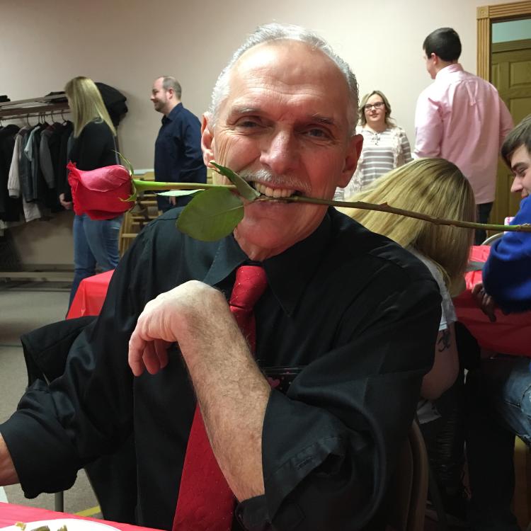 man with rose in his teeth
