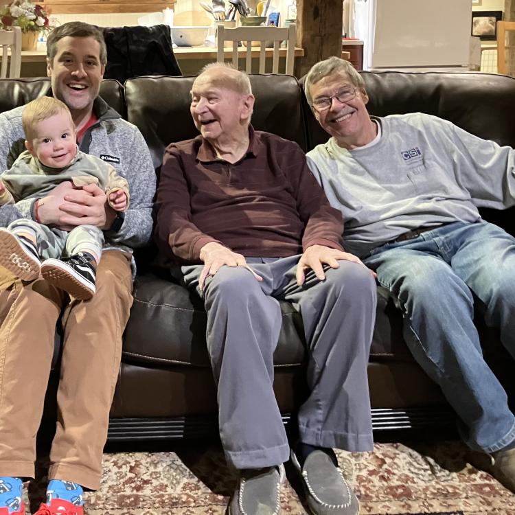 three men and a little boy on a couch