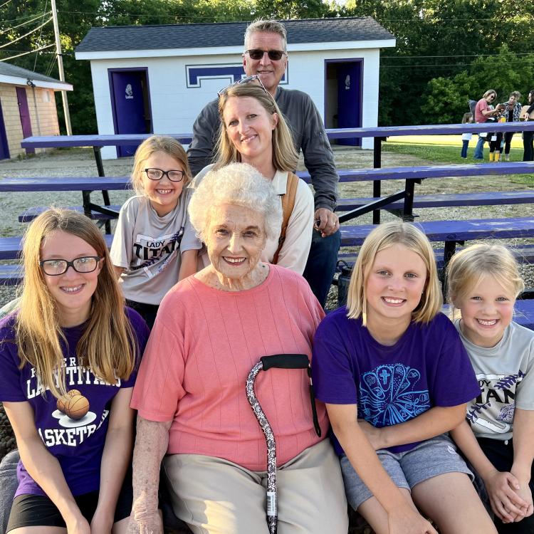 several generations of a family seated on bleachers