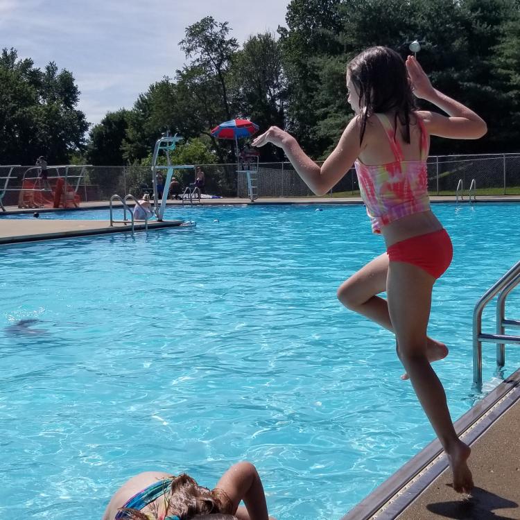 girl jumps in pool