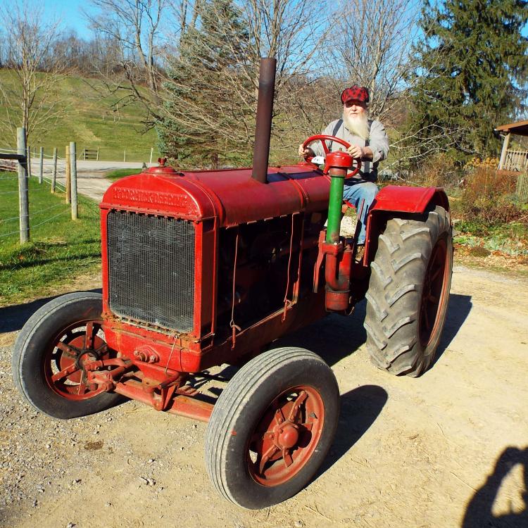 man on old red tractor