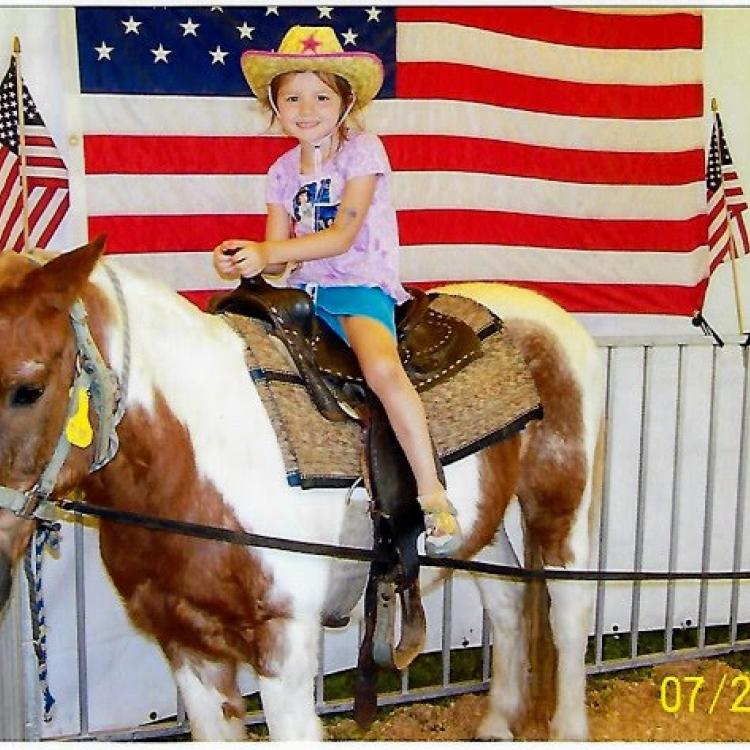 girl in cowboy hat on spotted pony