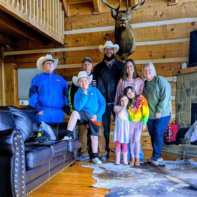 family in cabin beneath deer head on wall