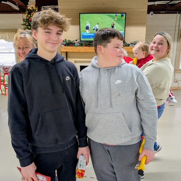 two boys photobombed by two women in back