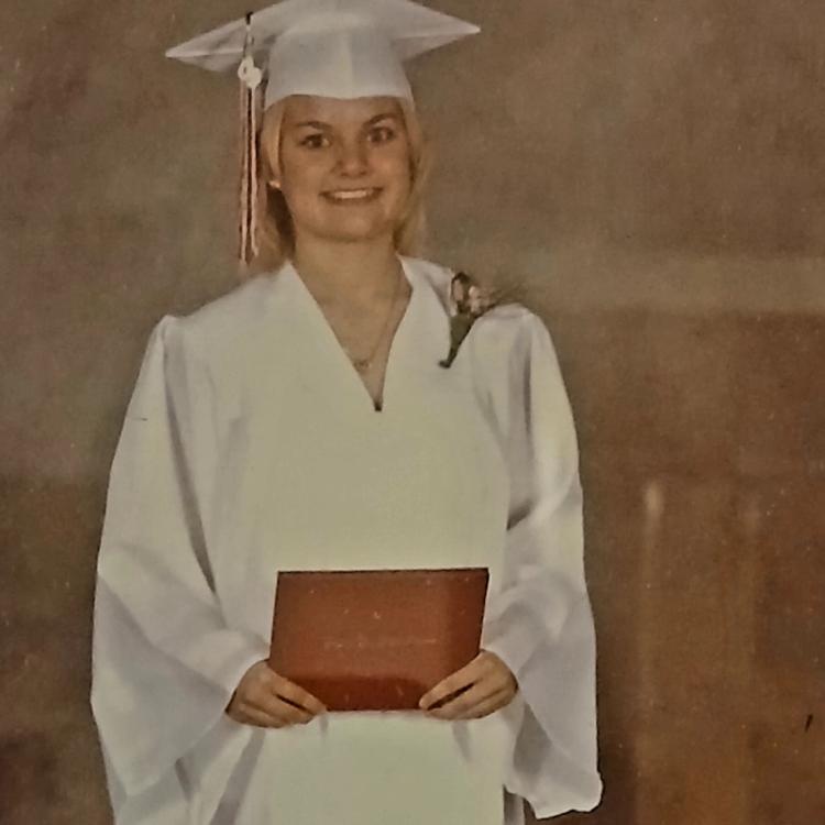 young woman in white cap and gown