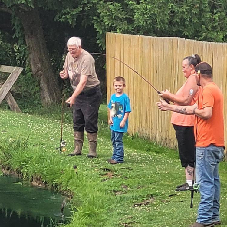 three adults and a little boy fishing