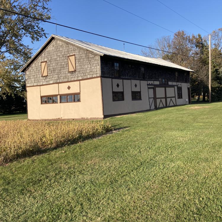 Tan stucco barn with dark brown trim.