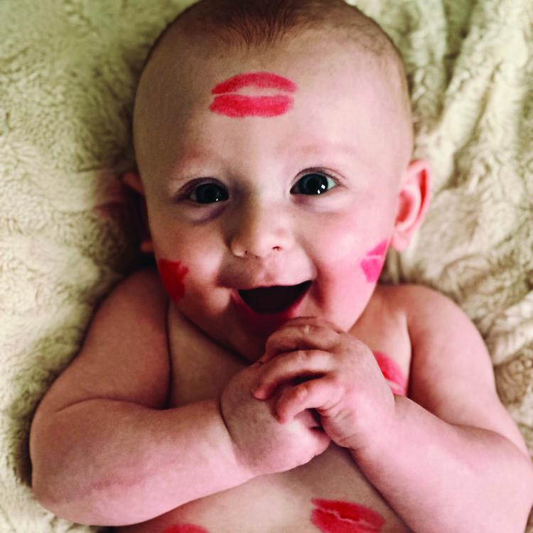 baby covered in lipstick kisses