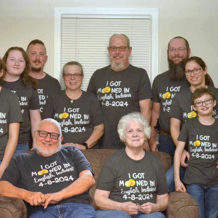 family group seated, in matching shirts