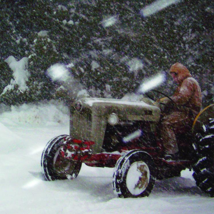 man on tractor in snow