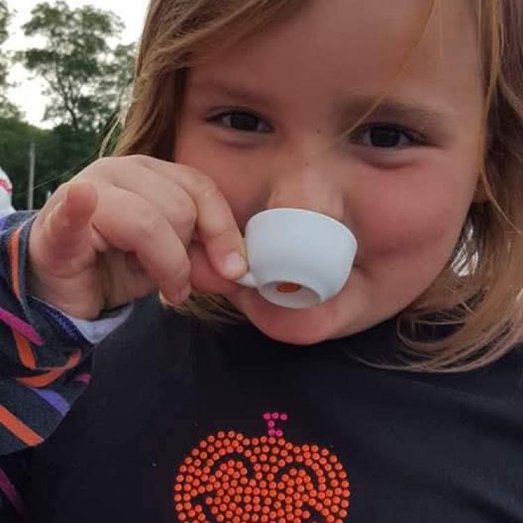 little girl drinking from tiny teacup