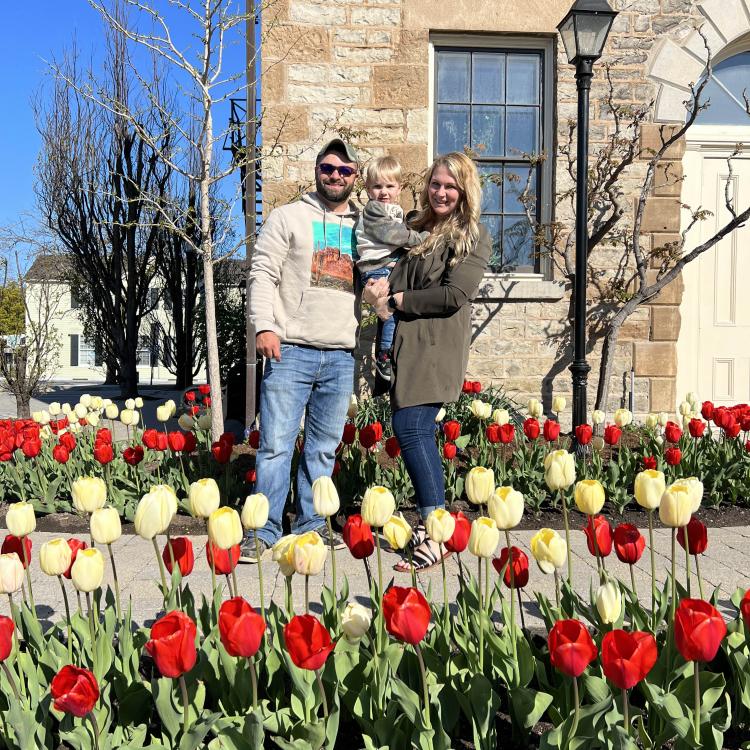 man, woman, and baby among tulips