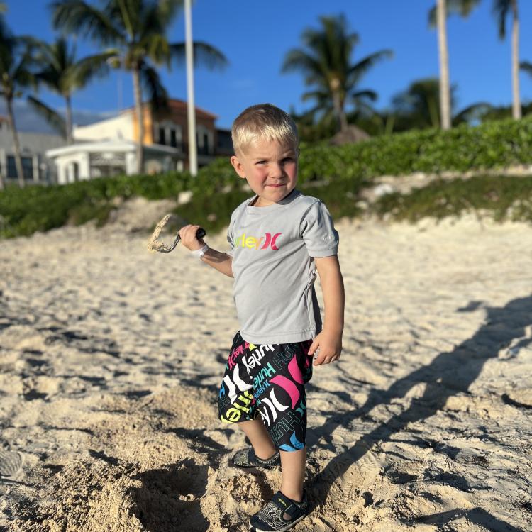 small boy next to sandcastle