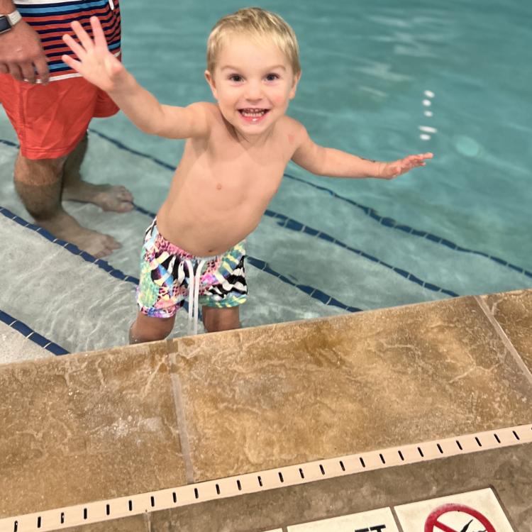 little boy on pool stairs