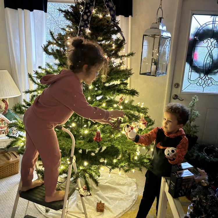 girl and boy decorating Christmas tree