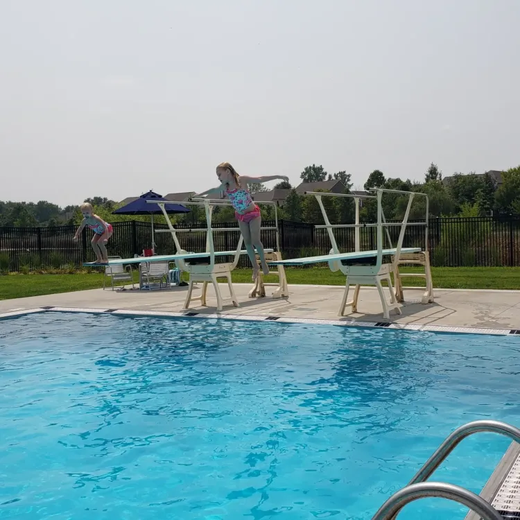 two girls jump off diving boards