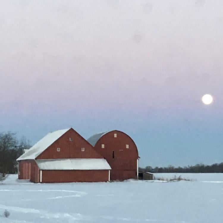 Big red barn surrounded by snowy fields